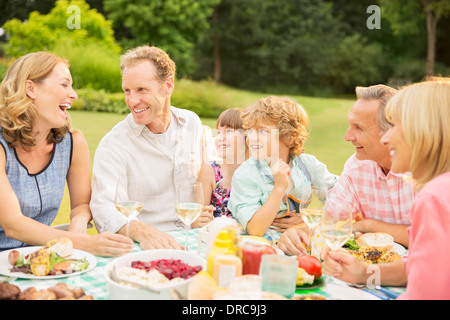 Multi-generation family enjoying lunch in backyard Stock Photo