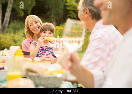 Family eating at table in backyard Stock Photo
