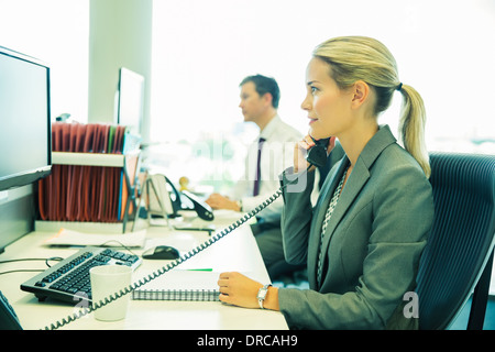 Businesswoman talking on telephone in office Stock Photo