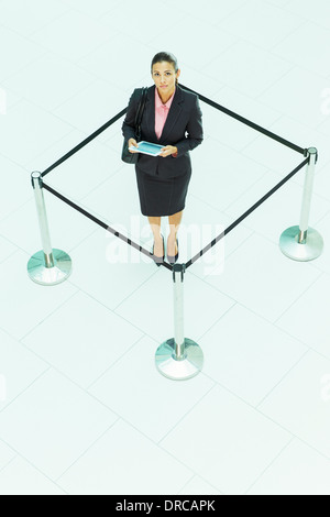 Businesswoman standing in roped-off square Stock Photo
