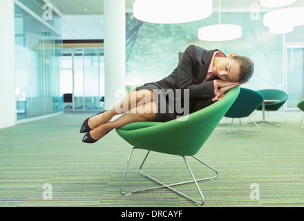 Businesswoman napping in office chair Stock Photo