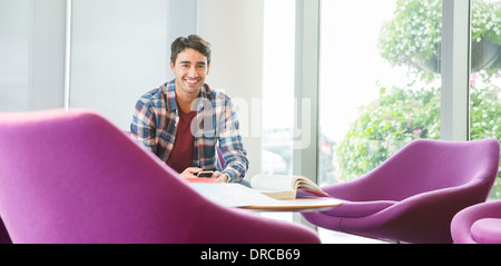Man using cell phone in lounge Stock Photo