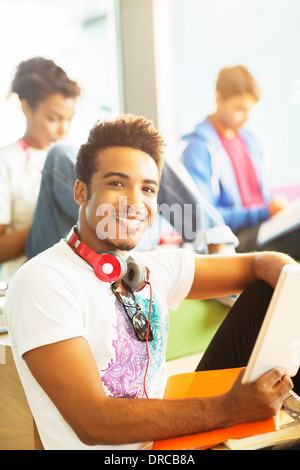 University students using digital tablet in lounge Stock Photo