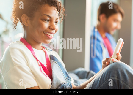 Woman using cell phone indoors Stock Photo