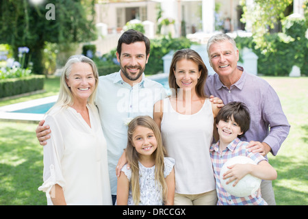 Multi-generation family smiling in backyard Stock Photo