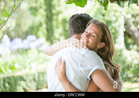 Couple hugging outdoors Stock Photo