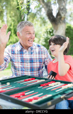 Grandfather and grandson playing backgammon Stock Photo