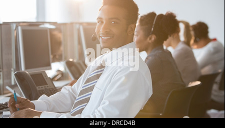 Businessman with headset smiling in office Stock Photo