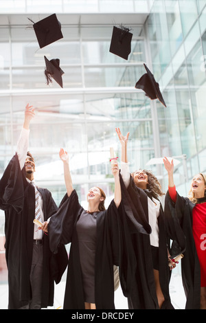 Graduates tossing caps in air Stock Photo