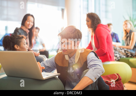 University student using laptop in lounge Stock Photo