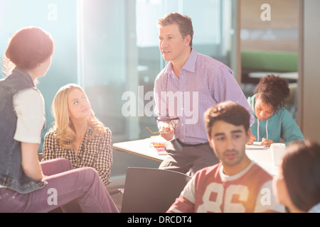 Professor and university students talking in classroom Stock Photo