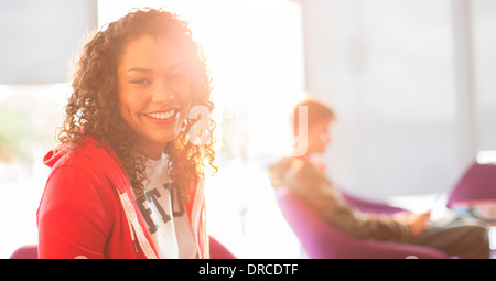 University student smiling in sunny lounge Stock Photo