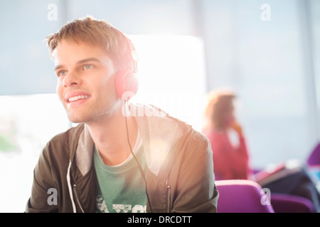 Young man listening to headphones indoors Stock Photo
