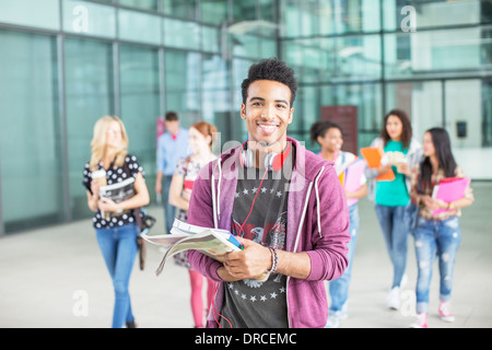 Smiling university student carrying books Stock Photo