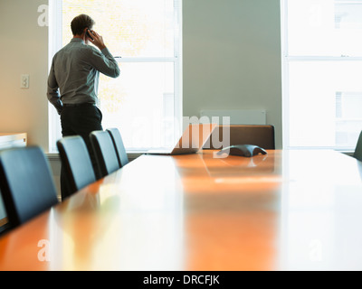 Businessman talking on cell phone in conference room Stock Photo