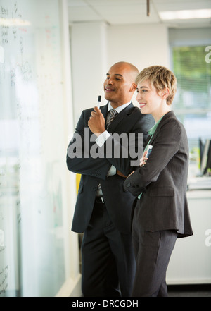 Business people looking at whiteboard in office Stock Photo