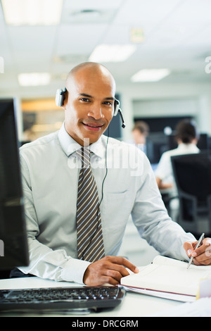 Businessman wearing headset in office Stock Photo