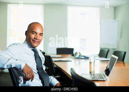 Businessman smiling at conference table Stock Photo