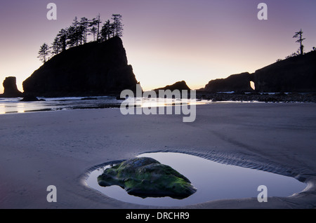 Silhouette of cliffs on beach at low tide Stock Photo