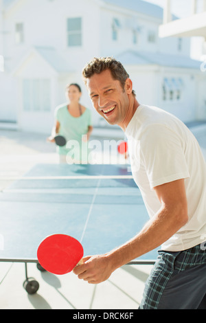 Couple playing table tennis outdoors Stock Photo