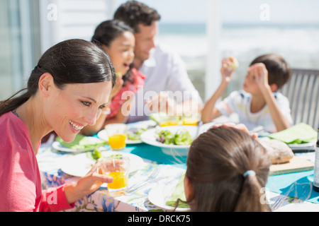Family eating lunch at table on sunny patio Stock Photo