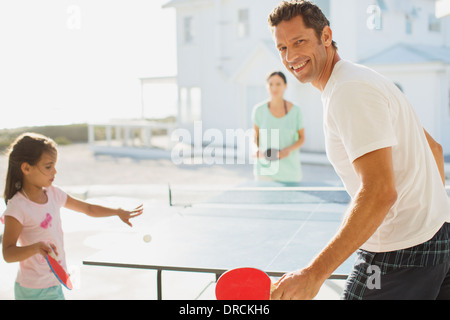 Family playing table tennis outside house Stock Photo