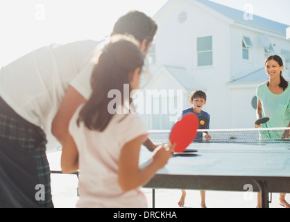 Family playing table tennis outside house Stock Photo