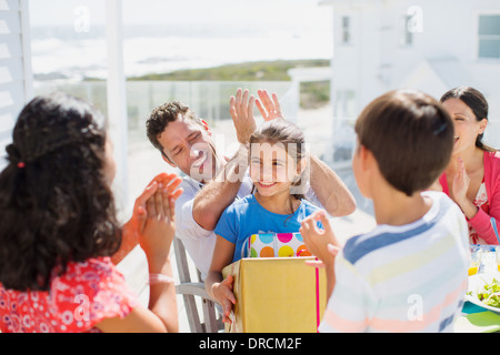 Family celebrating birthday on sunny patio Stock Photo