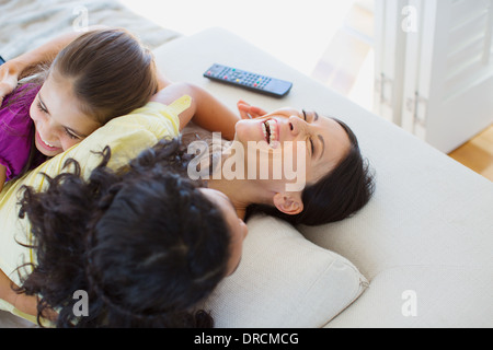 Mother and daughters laughing on sofa Stock Photo