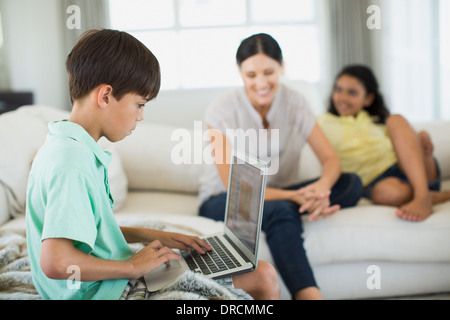 Boy using laptop on sofa in living room Stock Photo