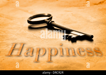 Key to Happiness on an old worn wooden desk top Stock Photo