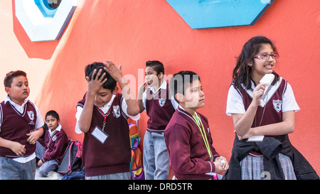 group of students in uniform stand outside primary school General Vicente Guerrero enjoying treats & waiting for parents Mexico Stock Photo