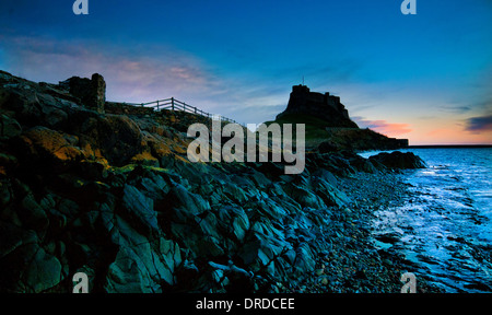 Dawn on the Holy Island and the castle which stands guard over the harbour, Lindisfarne Castle Stock Photo