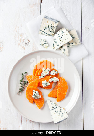 Pumpkin with blue cheese on white wooden background Stock Photo