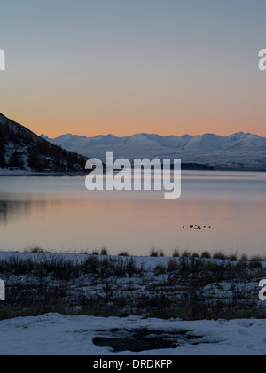 Sunset falls over Lake Tekapo, New Zealand, with the Two Thumbs Range in the background. Stock Photo