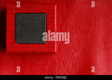 Red black rectangular ring jewellery box on leather background Stock Photo