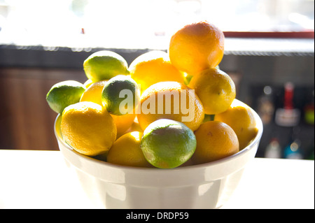 Bowl of lemons and limes on bar Stock Photo