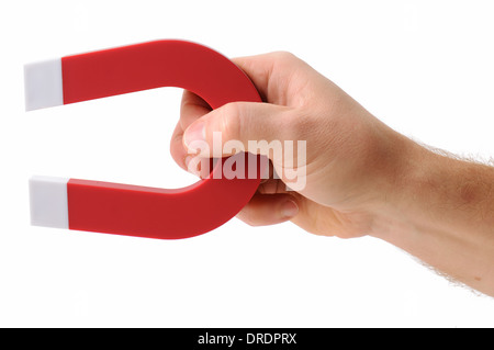 A hand holding a magnet isolated on white to pick up an object Stock Photo