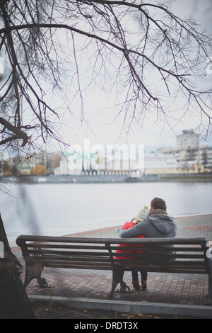 Image of affectionate young couple sitting on the bench in park Stock Photo