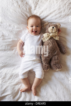 Baby laying on blanket with teddy bear Stock Photo