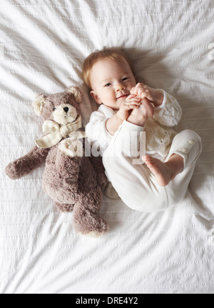 Baby laying on blanket with teddy bear Stock Photo