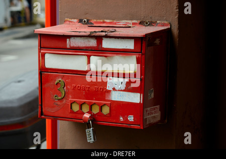 Weathered red post box on pillar with combination lock Stock Photo