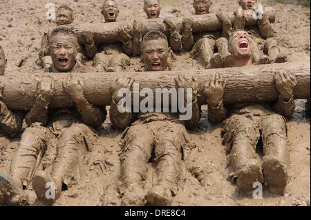 MUDDY COPS These are no bog-standard training methods. Rookie police wannabes are literally dragged into the mire by their tough, non nonsense boot camp drill sergeant as they slog through the swampy terrain. Each participant at the Police Training College in Chuzhou City, Anhui Province, China, aims to graduate from aspiring boys-in-blue aim to graduate to full-fledged copper . .  Stock Photo