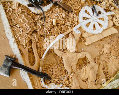 skillful engravements. carving tools are lying on the panel. hand made for a temple in Thailand. Stock Photo