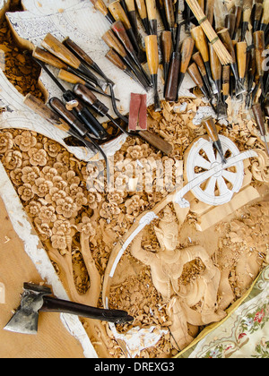skillful engravements. carving tools are lying on the panel. hand made for a temple in Thailand. Stock Photo