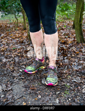 Trainers covered in mud after running through woodland. Stock Photo