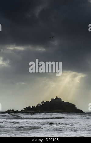 Sunlight breaking through storm clouds over St Michaels Mount in Cornwall.
