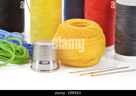 Sewing accessories. Few needles, threads and thimble isolated on white background. Stock Photo
