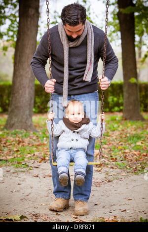 Father pushing son on a swing, Osijek, Croatia Stock Photo