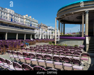 Rows of empty sunlit seats / chairs at Eastbourne Bandstand, Eastbourne, East Sussex, England, UK Stock Photo